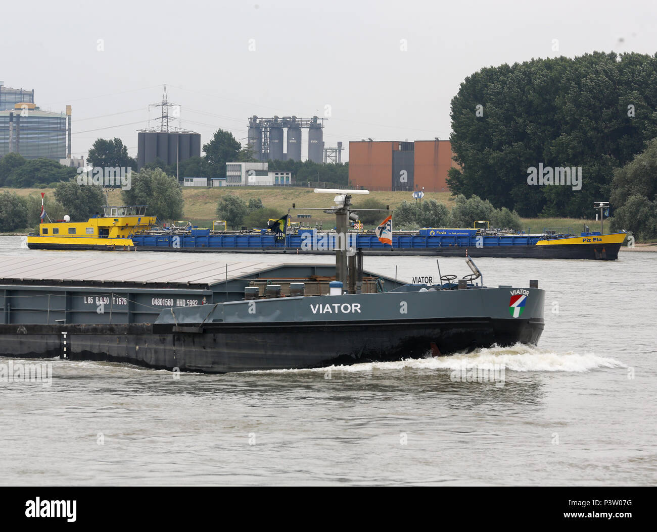 Duisburg, Germany. 19th June, 2018. A load ship passes the leaking caustic soda tanker 'Piz Ela' (back) on the Rhine at Duisburg. A second tanker is supposed to take over the load so the stranded vessel becomes lighter and might get out. Credit: Roland Weihrauch/dpa/Alamy Live News Stock Photo
