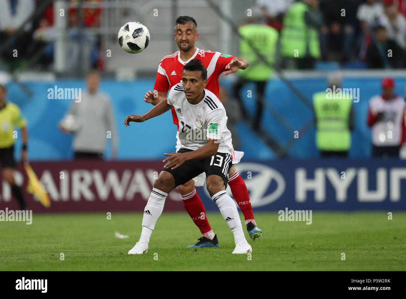 Saint Petersburg, Russia. 19th June, 2018. Egypt's Mohamed Abdel-Shafy (front) battles for the ball with Russia's Aleksandr Samedov during the FIFA World Cup 2018 Group A soccer match between Egypt and Russia, at the Saint Petersburg Stadium, in Saint Petersburg, Russia, 19 June 2018. Credit: Ahmed Ramadan/dpa/Alamy Live News Stock Photo