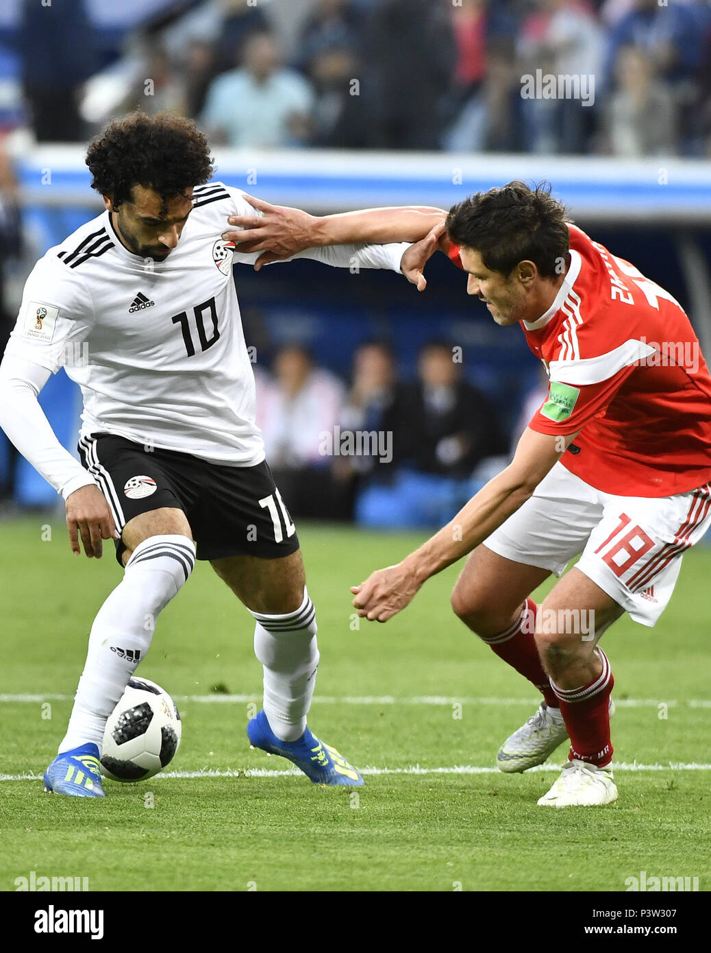 Saint Petersburg, Russia. 19th June, 2018. Mohamed Salah (L) of Egypt vies with Yury Zhirkov of Russia during a Group A match between Russia and Egypt at the 2018 FIFA World Cup in Saint Petersburg, Russia, June 19, 2018. Credit: Chen Yichen/Xinhua/Alamy Live News Stock Photo