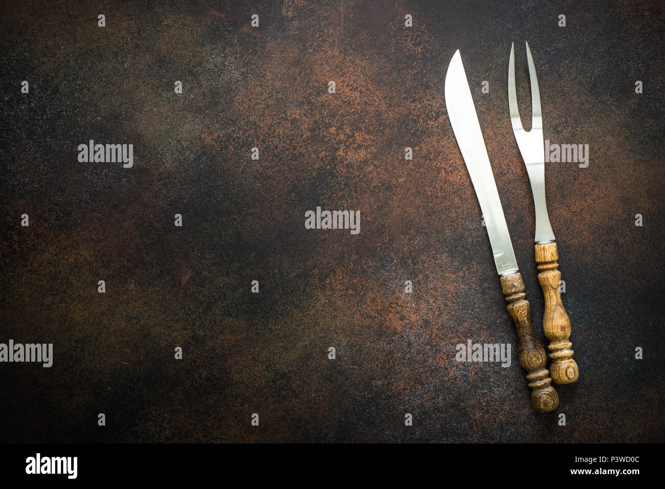 Vintage kitchen utensils meat fork and knife on rusty stone table