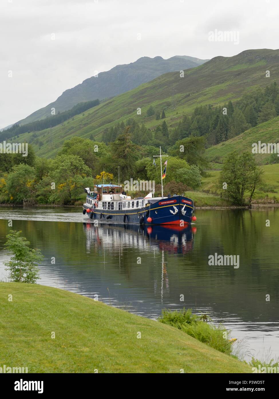 The Hotel Barge Scottish Highlander passing through Laggan on the Caledonian Canal in Highland, Scotland, UK Stock Photo