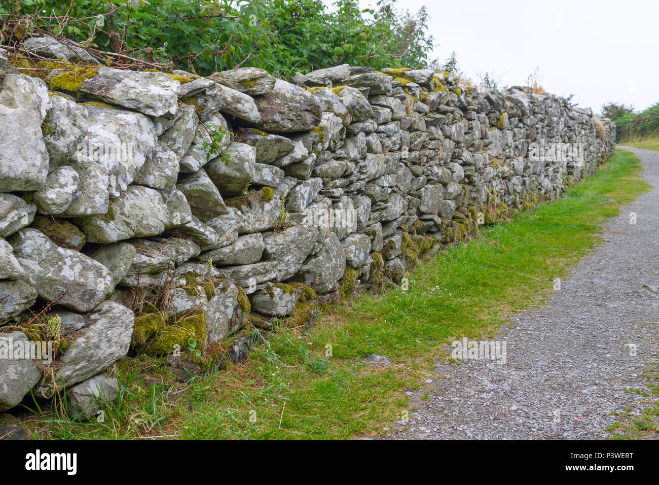 dry stone wall alongside a footpath. Stock Photo