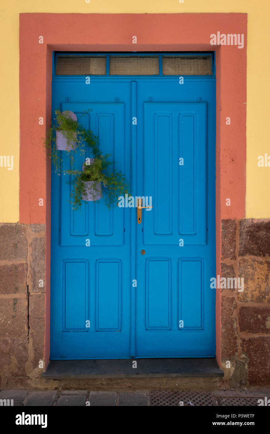 Wooden Blue Front Door At A House With A Yellow Facade And A Red