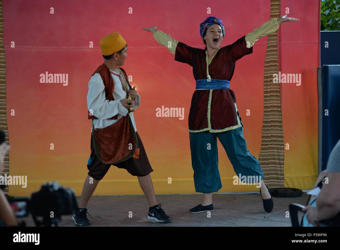 SINGAPORE (July 29, 2016) – Kainalu Szewczyk, left, who portrays Aladdin and Carlysle Garland, portraying Genie, perform in a rendition of Aladdin at the upper patio of U.S. Navy Region Center Singapore's (NRCS) Terror Club July 29, 2016. The NRCS community members shared laughter and drama with the Missoula Children’s Theatre (MCT) actors and tour directors along with children of military service members and DoD civilians assigned to NRCS. Stock Photo