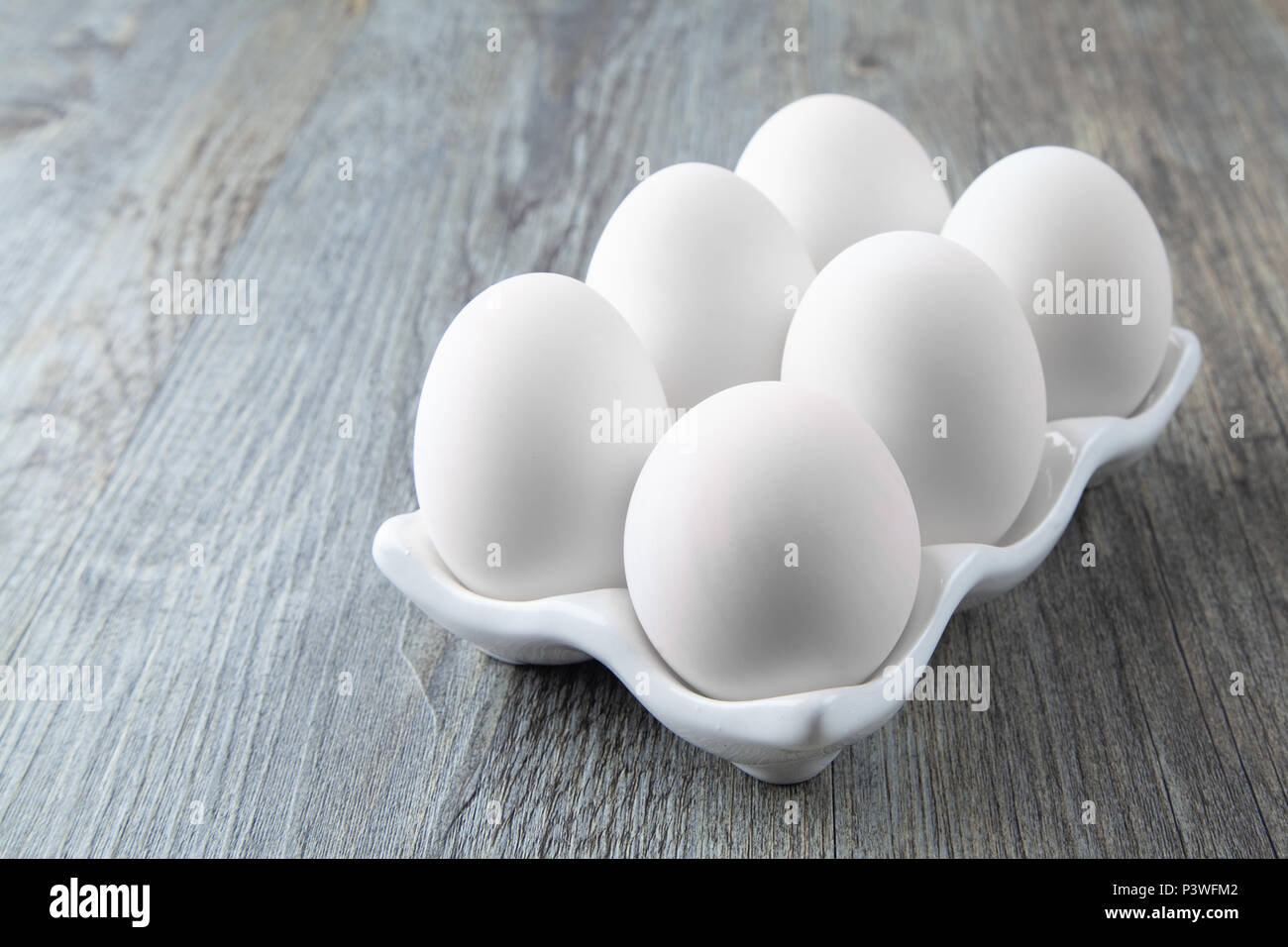 Six Large White Eggs on a White Ceramic Dish Stock Photo