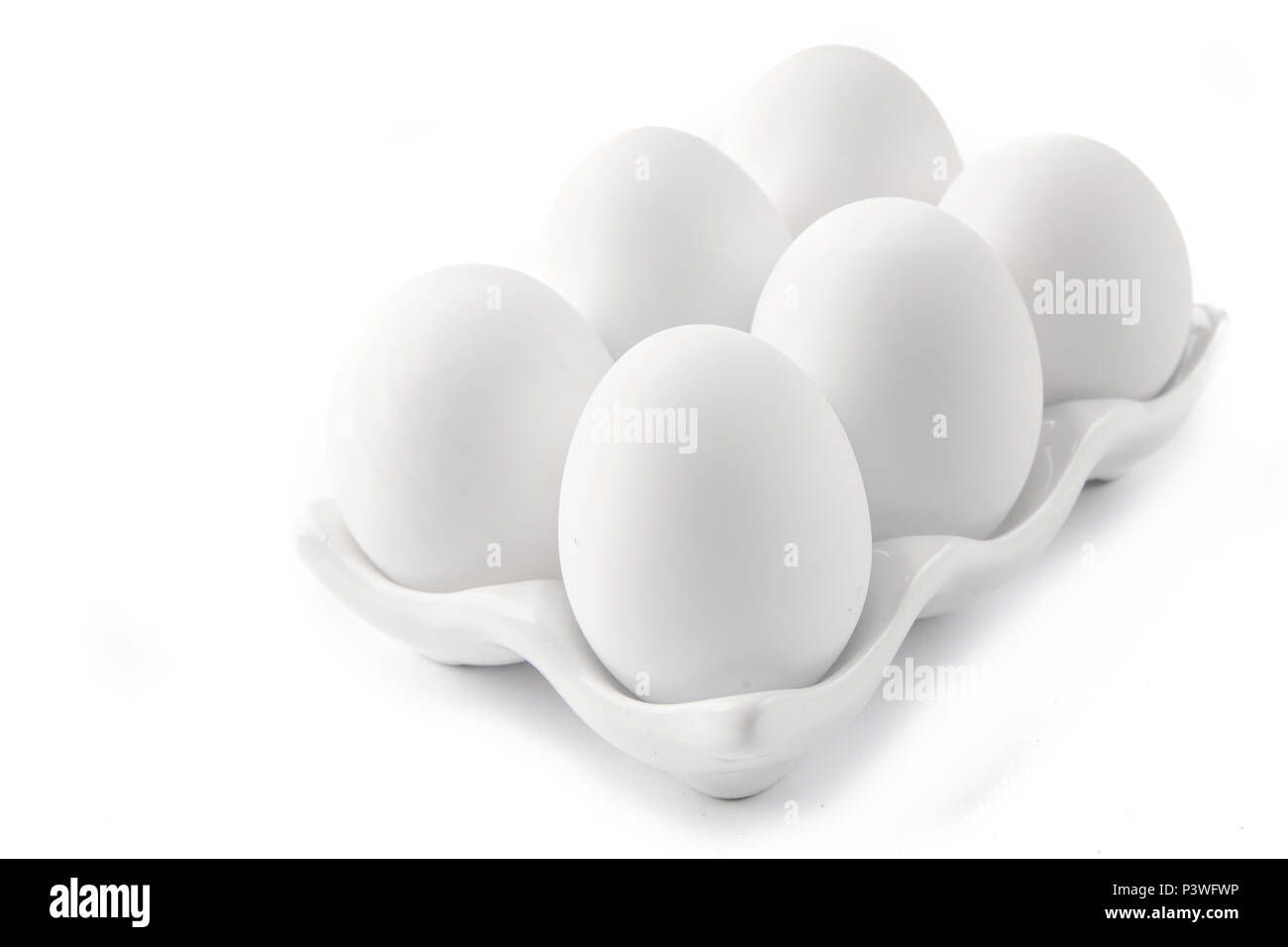 Six Large White Eggs on a White Ceramic Dish Stock Photo