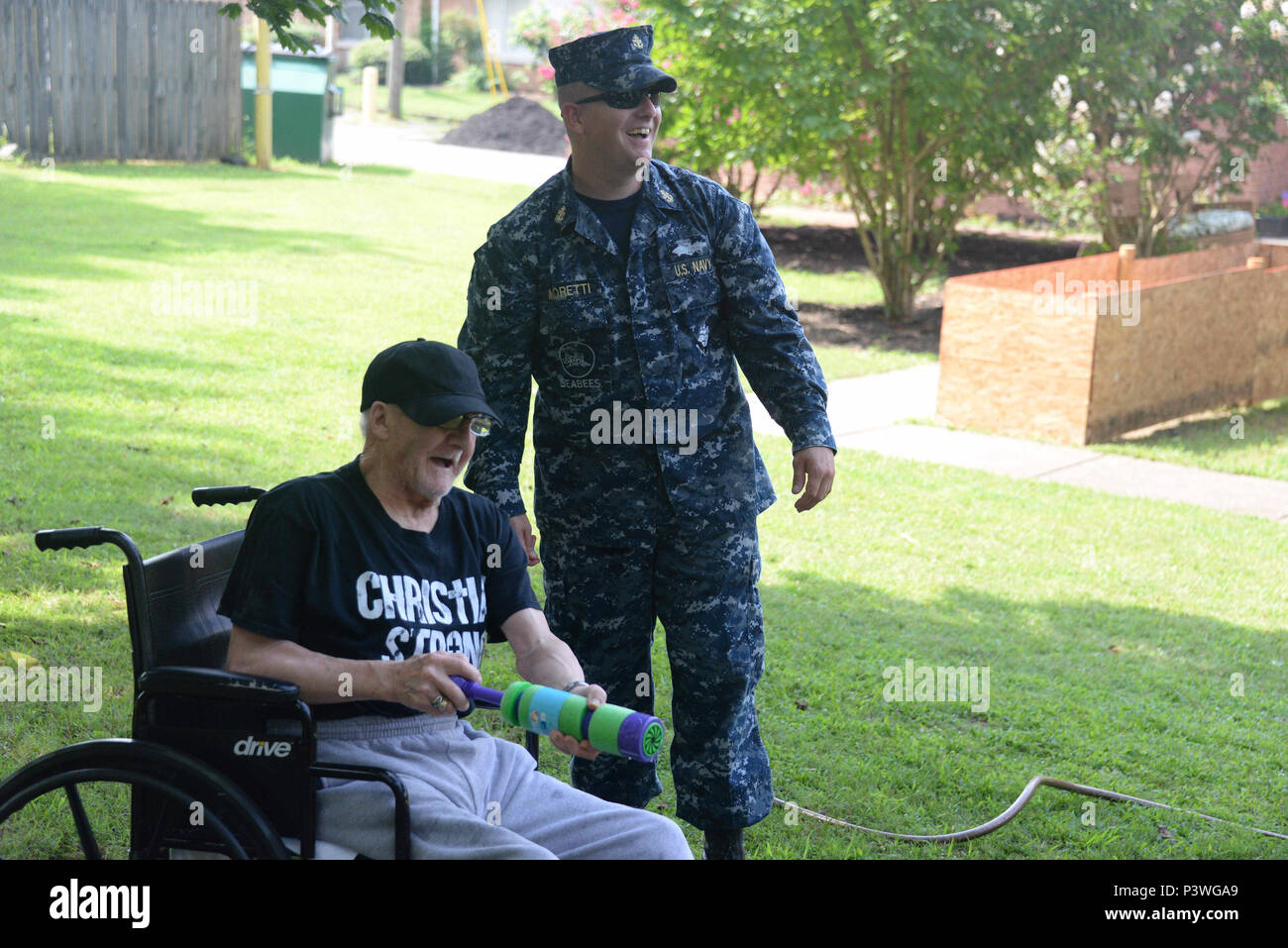 160722-N-FU443-013 NASHVILLE (July 22, 2016) Chief Equipment Operator Michael Moretti cheers on a resident during an outdoor game where residents attempted to sink paper battleships with squirt guns and water balloons at the Azalea Trace Assisted Living facility. Several members of Navy Recruiting District Nashville volunteered for the event in order to reach out to local members of the community. (U.S. Navy photo by Mass Communication Specialist 1st Class Timothy Walter/Released) Stock Photo