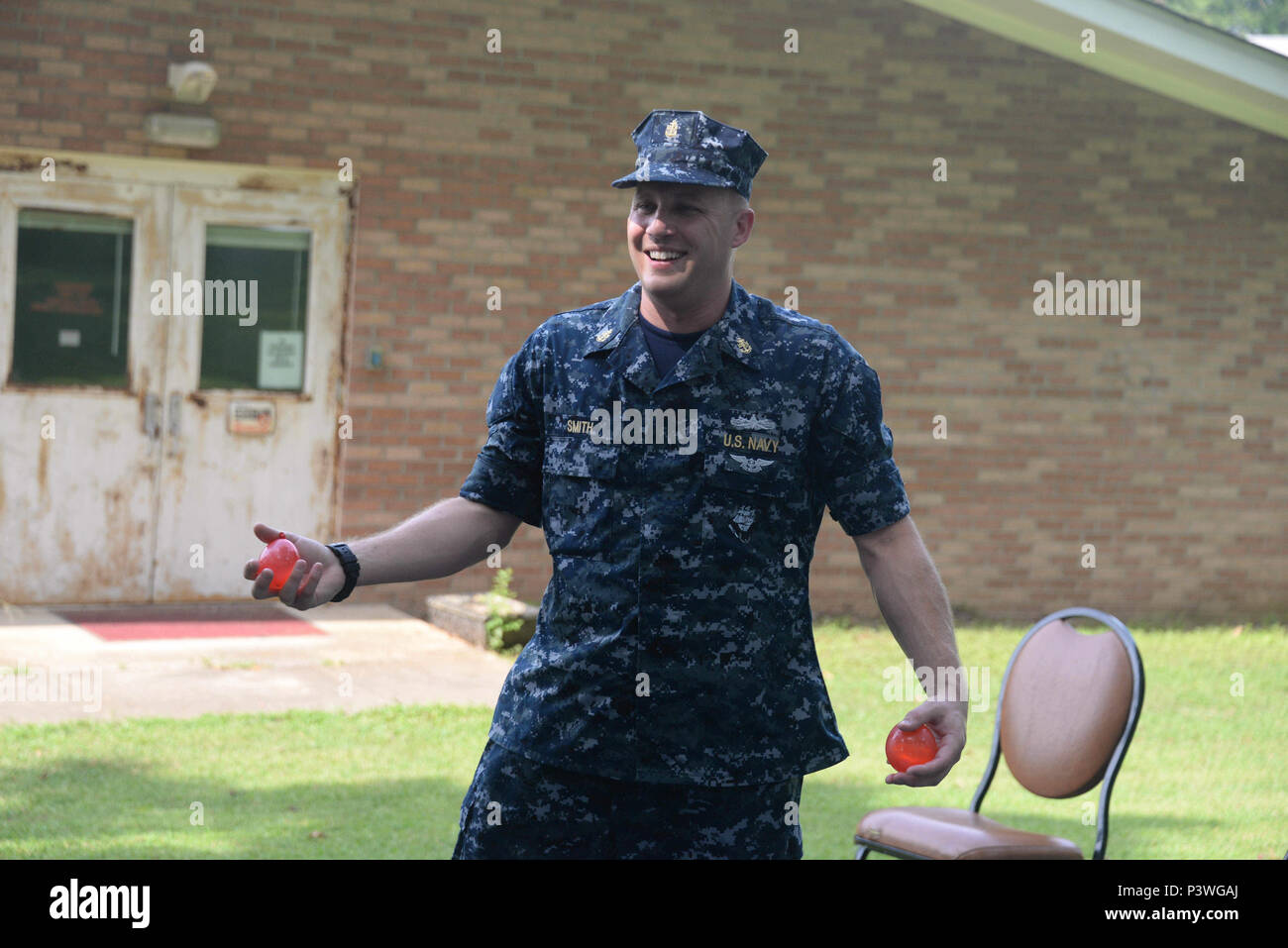 160722-N-FU443-020 NASHVILLE (July 22, 2016) Chief Electrician's Mate (Nuclear) Jeremy Smith assists with handing out water balloons during an outdoor game where residents attempted to sink paper battleships with squirt guns and water balloons at the Azalea Trace Assisted Living facility. Several members of Navy Recruiting District Nashville volunteered for the event in order to reach out to local members of the community. (U.S. Navy photo by Mass Communication Specialist 1st Class Timothy Walter/Released) Stock Photo