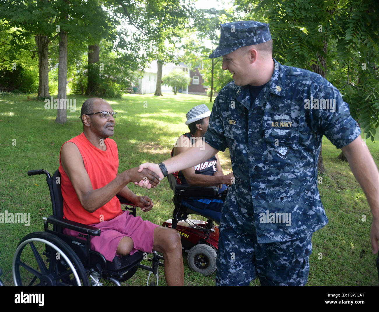 160722-N-FU443-027 NASHVILLE (July 22, 2016) Chief Electrician's Mate (Nuclear) Jeremy Smith congratulates a residents after an outdoor game where the residents attempted to sink paper battleships with squirt guns and water balloons at the Azalea Trace Assisted Living facility. Several members of Navy Recruiting District Nashville volunteered for the event in order to reach out to local members of the community. (U.S. Navy photo by Mass Communication Specialist 1st Class Timothy Walter/Released) Stock Photo