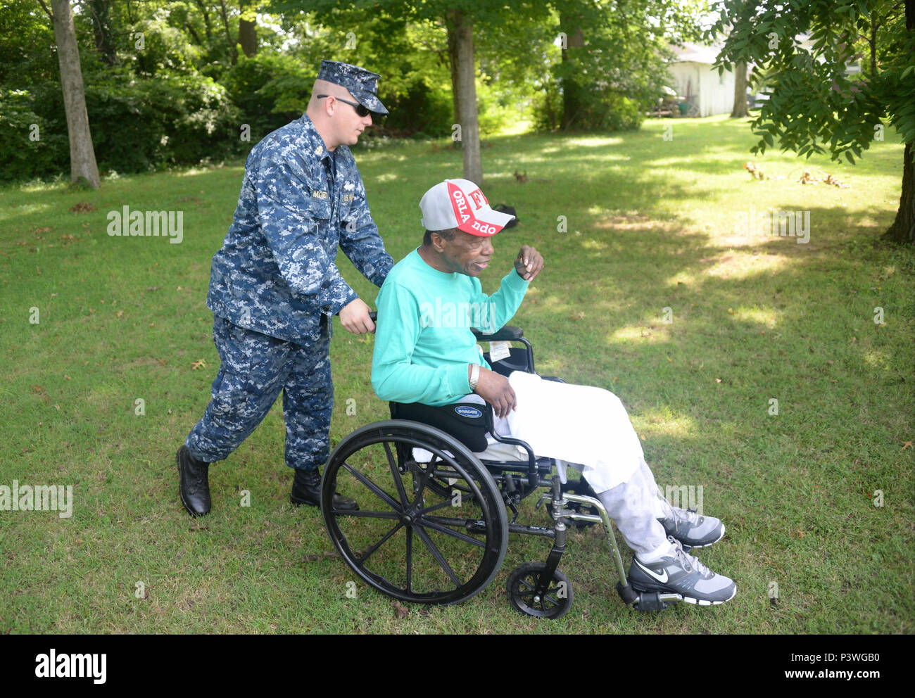 160722-N-FU443-029 NASHVILLE (July 22, 2016) Chief Equipment Operator Michael Moretti helps transport a resident following an outdoor game where residents attempted to sink paper battleships with squirt guns and water balloons at the Azalea Trace Assisted Living facility. Several members of Navy Recruiting District Nashville volunteered for the event in order to reach out to local members of the community. (U.S. Navy photo by Mass Communication Specialist 1st Class Timothy Walter/Released) Stock Photo