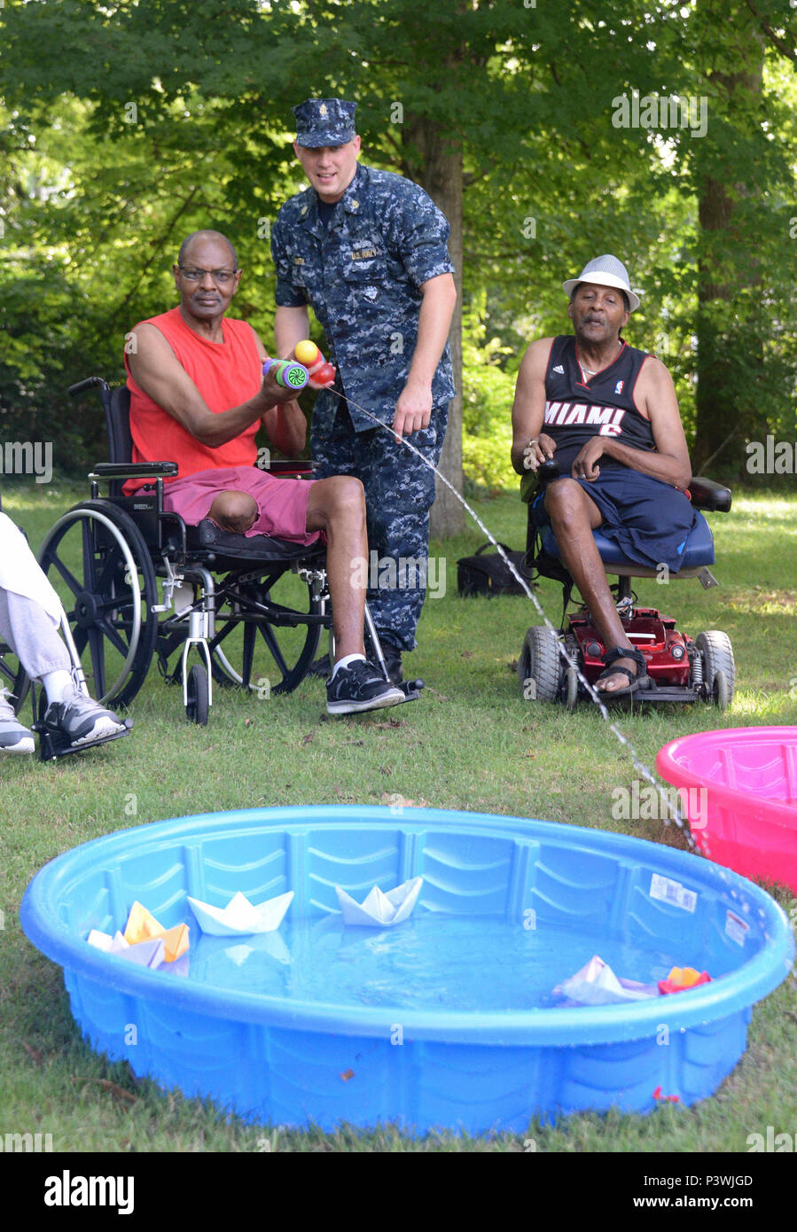 160722-N-FU443-008 NASHVILLE (July 22, 2016) Chief Electrician's Mate (Nuclear) Jeremy Smith leads an outdoor game where residents of the Azalea Trace Assisted Living facility attempt to sink paper battleships with squirt guns and water balloons. Several members of Navy Recruiting District Nashville volunteered for the event in order to reach out to local members of the community. (U.S. Navy photo by Mass Communication Specialist 1st Class Timothy Walter/Released) Stock Photo