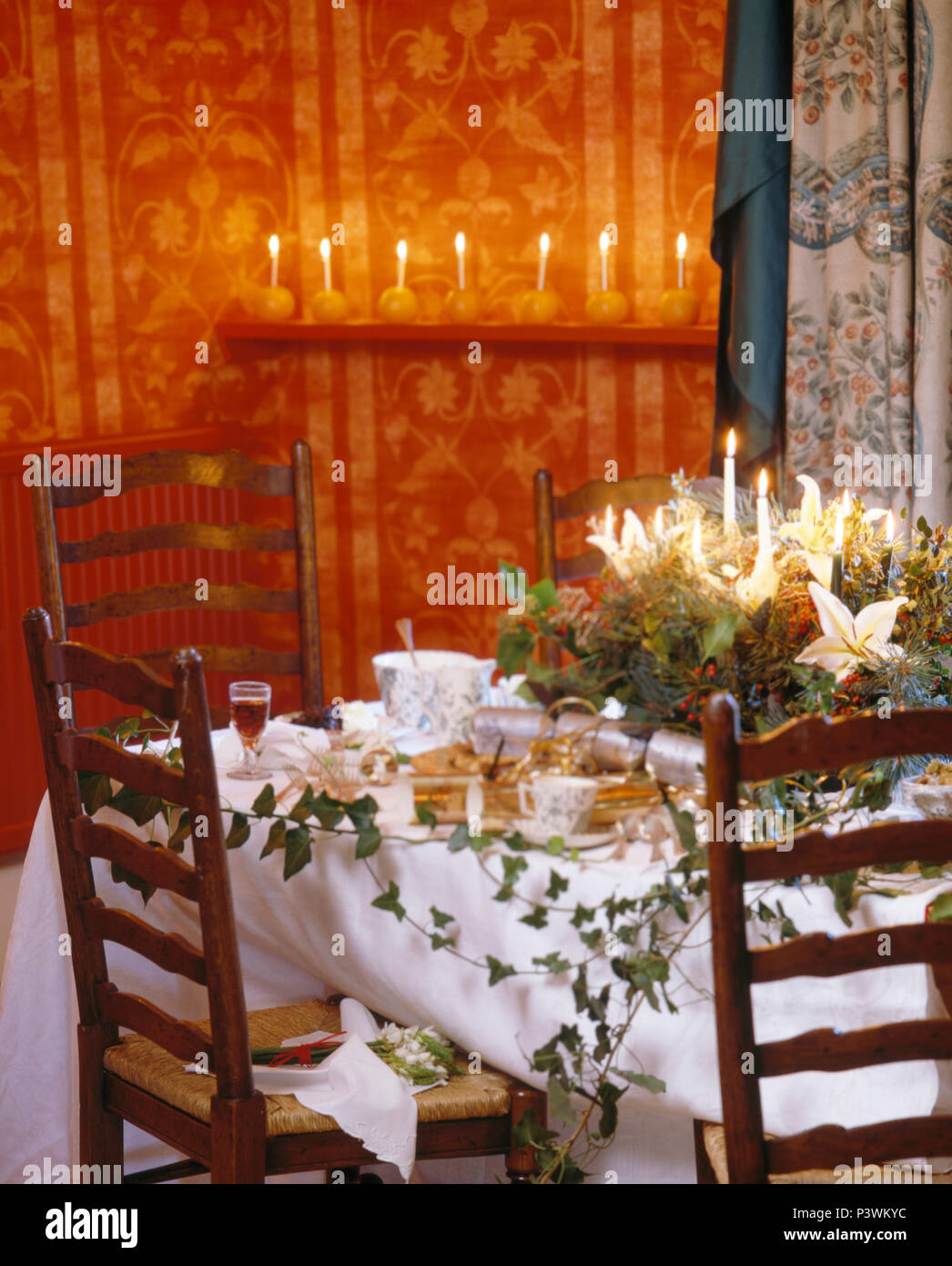 Arrangement Of Christmas Flowers And Lighted Candles On Table With