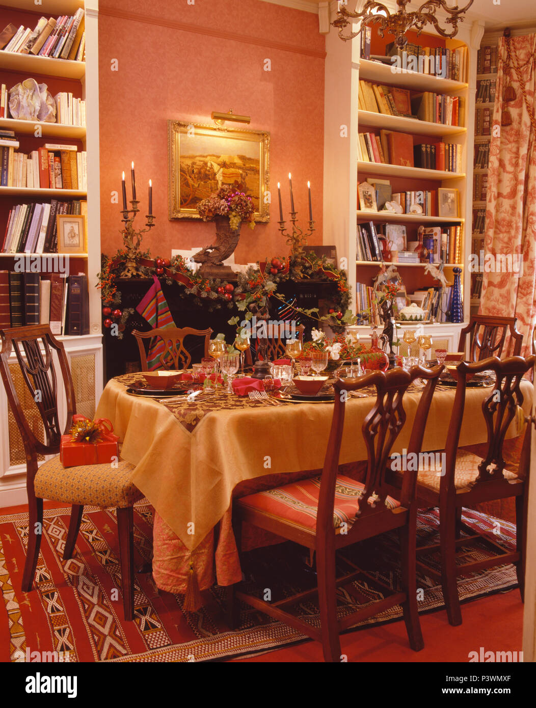 Table set for Christmas lunch with yellow cloth in terracotta country dining room Stock Photo