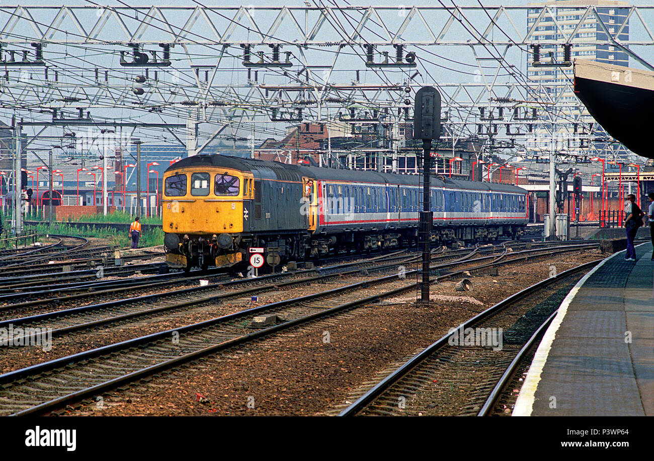 A class 33 diesel locomotive number 33030 hauling a Network SouthEast electric multiple unit through Stratford in east London on the 23rd August 1990. Stock Photo