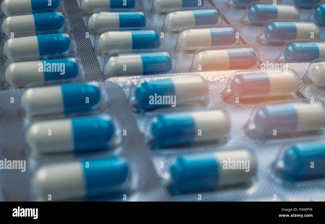 Blue and white capsules pill in blister pack arranged with beautiful pattern. Global healthcare