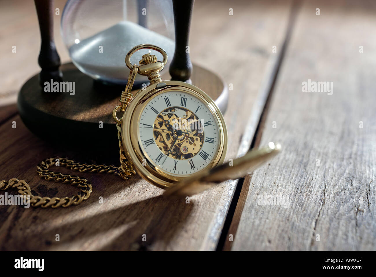 Vintage pocket watch and hour glass or sand timer, symbols of time with copy space Stock Photo