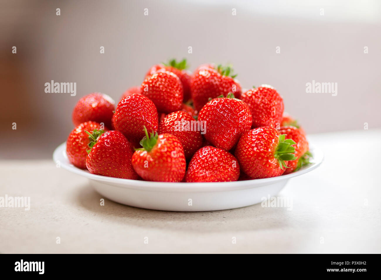 Fresh strawberries in a white bowl Stock Photo