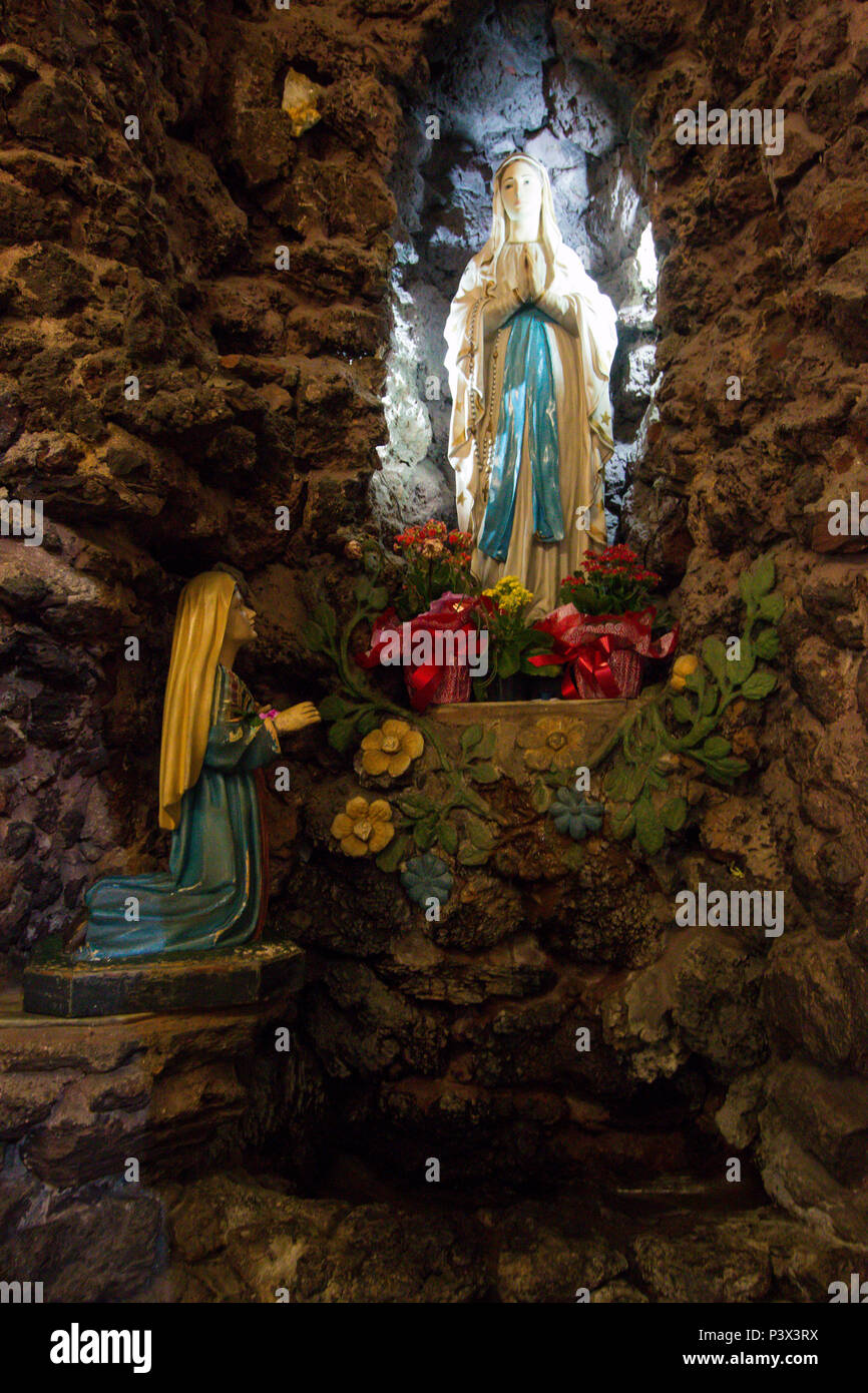 Imagem de Nossa Senhora de Lourdes, esculpida em gesso, com mais de 100 anos, localizada na Gruta de Lourdes, no interior da Basílica de Lourdes, local onde os fiéis fazem orações e pegam a água que fica aos pés da santa. A Basílica possui arquitetura predominantemente neogótica, situada na cidade de Belo Horizonte, Minas Gerais. Stock Photo