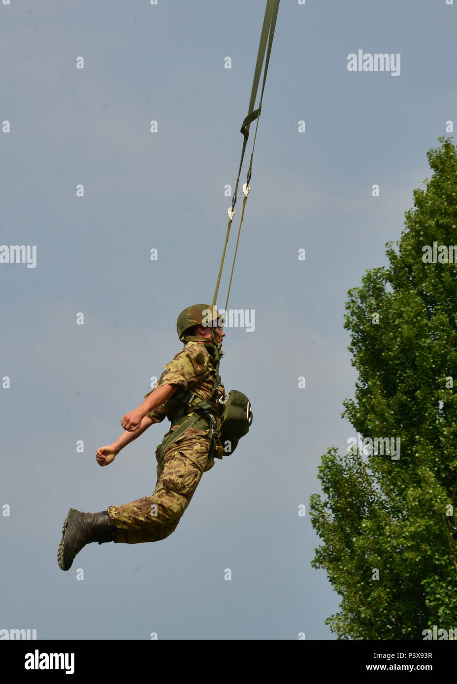 An Italian army cadet, assigned to the Centre of Excellence Italian Airborne Folgore in Pisa, exits the 7th Army Training Command tower during basic airborne training at Caserma Ederle, Vicenza, Italy, July 12, 2016. The 7th Army Training Command tower is 34-feet high and the only Army jump tower in Europe. (Photo by Visual Information Specialist Massimo Bovo/Released) Stock Photo