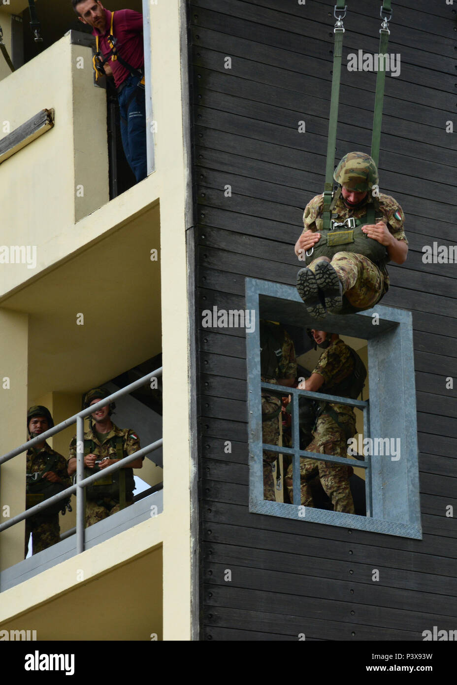 An Italian army cadet, assigned to the Centre of Excellence Italian Airborne Folgore in Pisa, exits the 7th Army Training Command tower during basic airborne training at Caserma Ederle, Vicenza, Italy, July 12, 2016. The 7th Army Training Command tower is 34-feet high and the only Army jump tower in Europe. (Photo by Visual Information Specialist Massimo Bovo/Released) Stock Photo