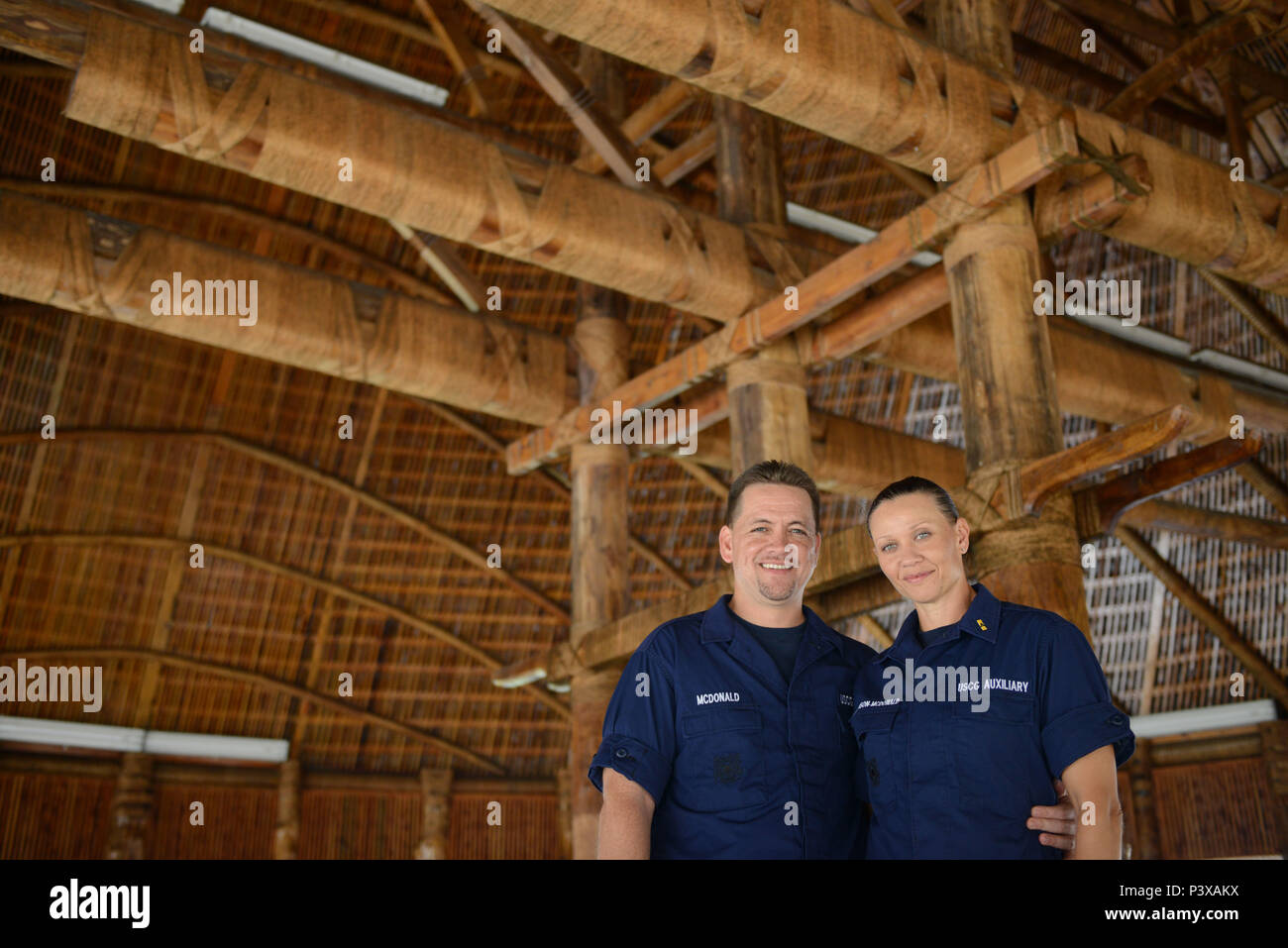 U.S. Coast Guard Auxiliarists Mike and Paula McDonald stand in a ‘fale’ or a traditional style Samoan house in the village of Utulei, American Samoa, July 21, 2016. The couple owns and operates South Pacific Watersports, a watercraft rental and fitness facility in the village of Utulei and are active members of Coast Guard Auxiliary Flotilla 3-28. (U.S. Coast Guard photo by Petty Officer 2nd Class Tara Molle) Stock Photo
