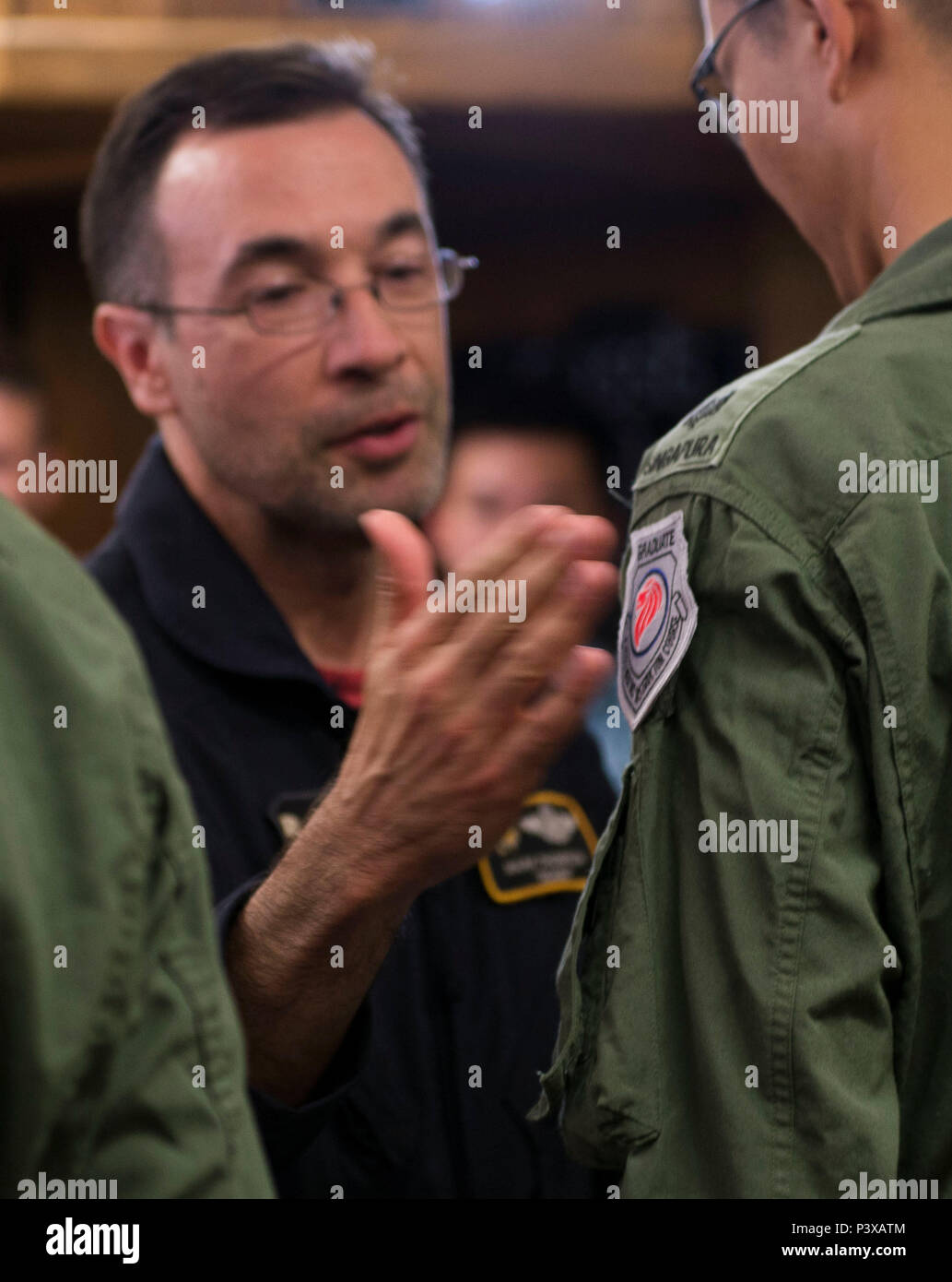 Mark Thompson, 428th Fighter Squadron F-15SG instructor pilot, patches Republic of Singapore Air Force Maj. Wang Kee Yong, 428th Fighter Squadron F-15SG pilot, during a patching ceremony July 22, 2016 at Mountain Home Air Force Base, Idaho. Normally limited to 'patches,' aircrew who have already earned their instructor patches, the ceremony marks the transition from student to teacher. (U.S. Air Force photo by Senior Airman Lauren-Taylor Levin/Released) Stock Photo