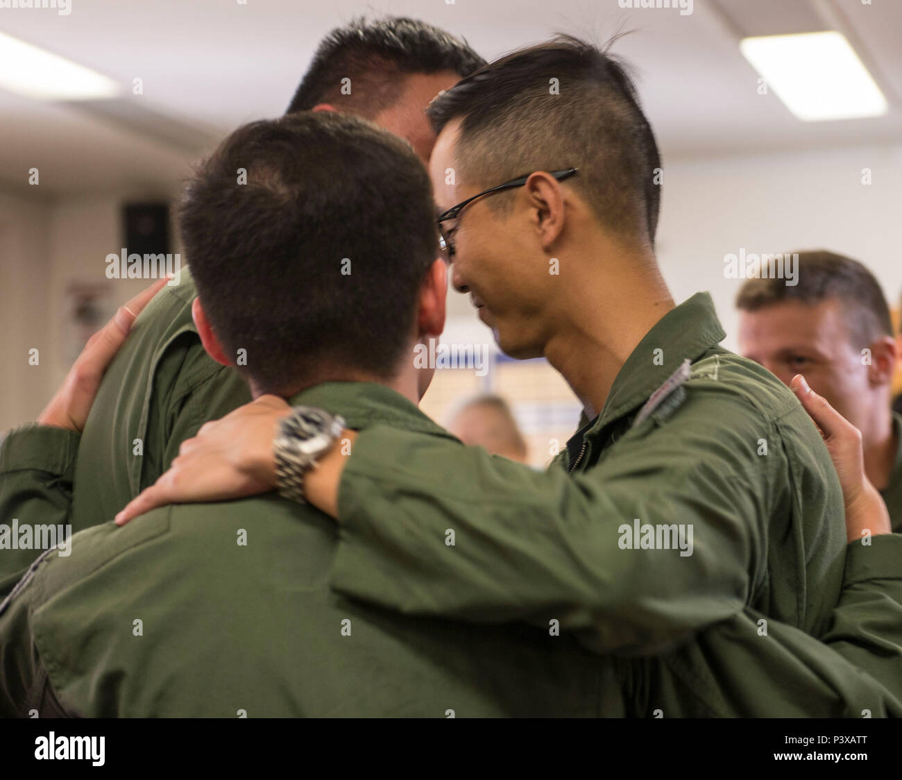 The Republic of Singapore Air Force Capts. Chia Chi Yu, and Alex Ong, 428th Fighter Squadron weapons systems officers, and Maj. Wang Kee Yong, 428th FS F-15SG pilot, hug after a patching ceremony July 22, 2016 at Mountain Home Air Force Base, Idaho. The three are the first to graduate the RSAF Fighter Weapons Instructor Course, modeled after the U.S. Air Force Fighter Weapons School program. (U.S. Air Force photo by Senior Airman Lauren-Taylor Levin/Released) Stock Photo
