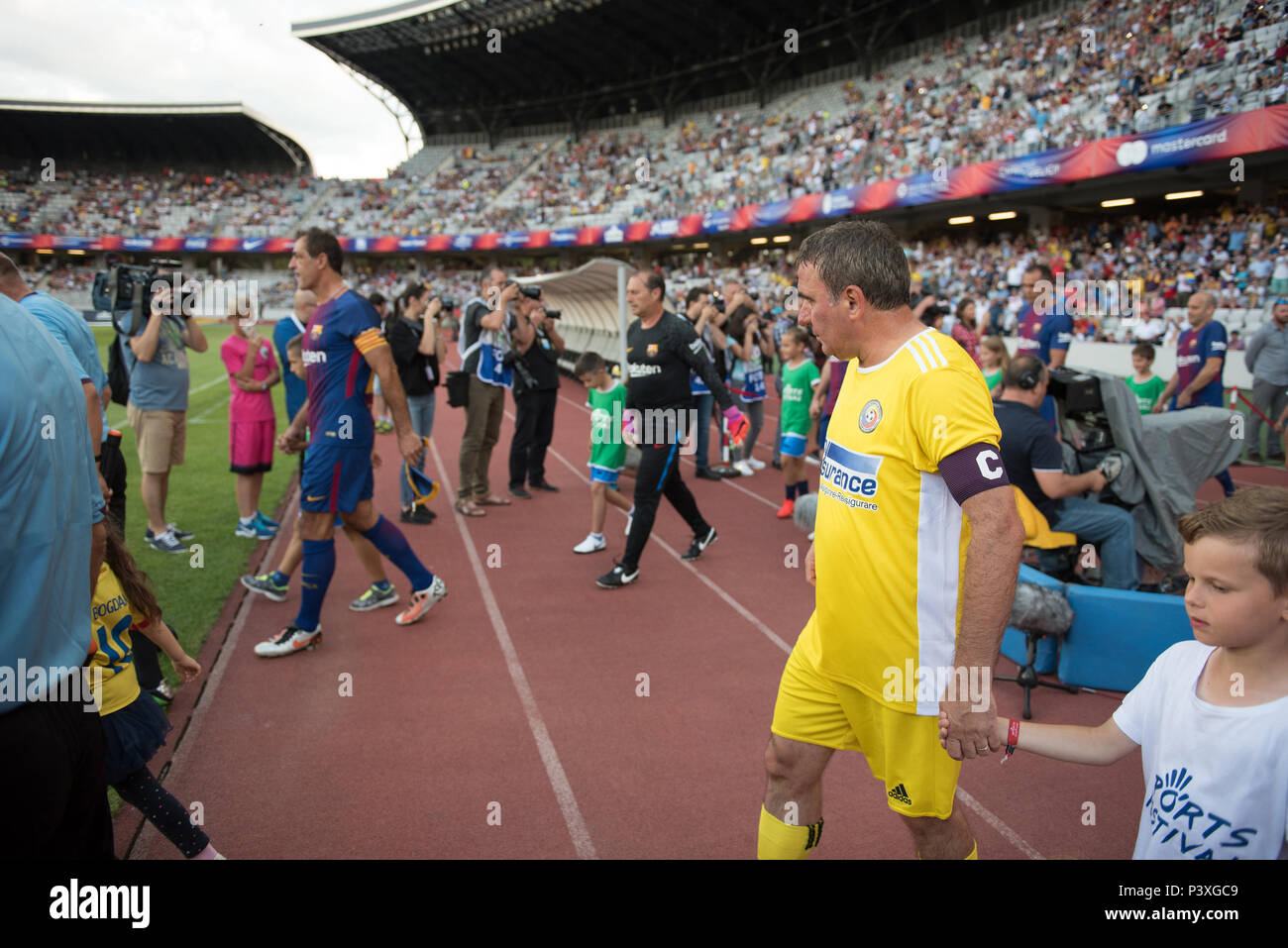 CLUJ, ROMANIA - JUNE 16, 2018: Football player Gheorghe Hagi (Romania Golden Team) and Barcelona Legends entering the playfield at the beginning of a  Stock Photo