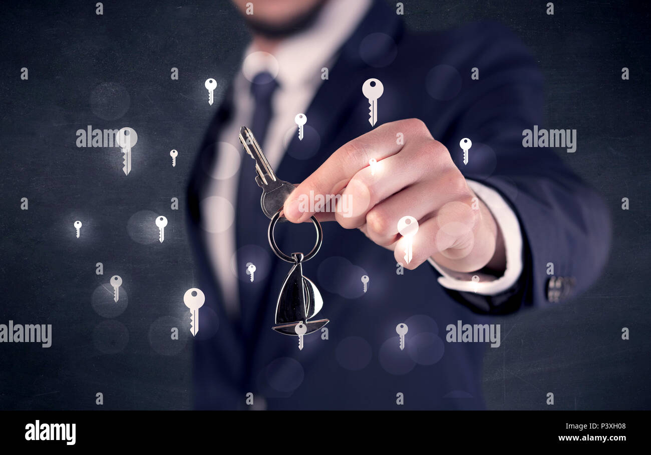 Businessman in suit holding keys with keys graphics around and dark background  Stock Photo