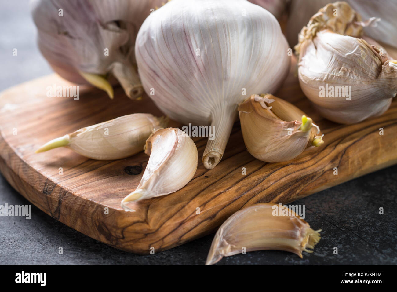 Garlic cloves on a dark stone background Stock Photo - Alamy