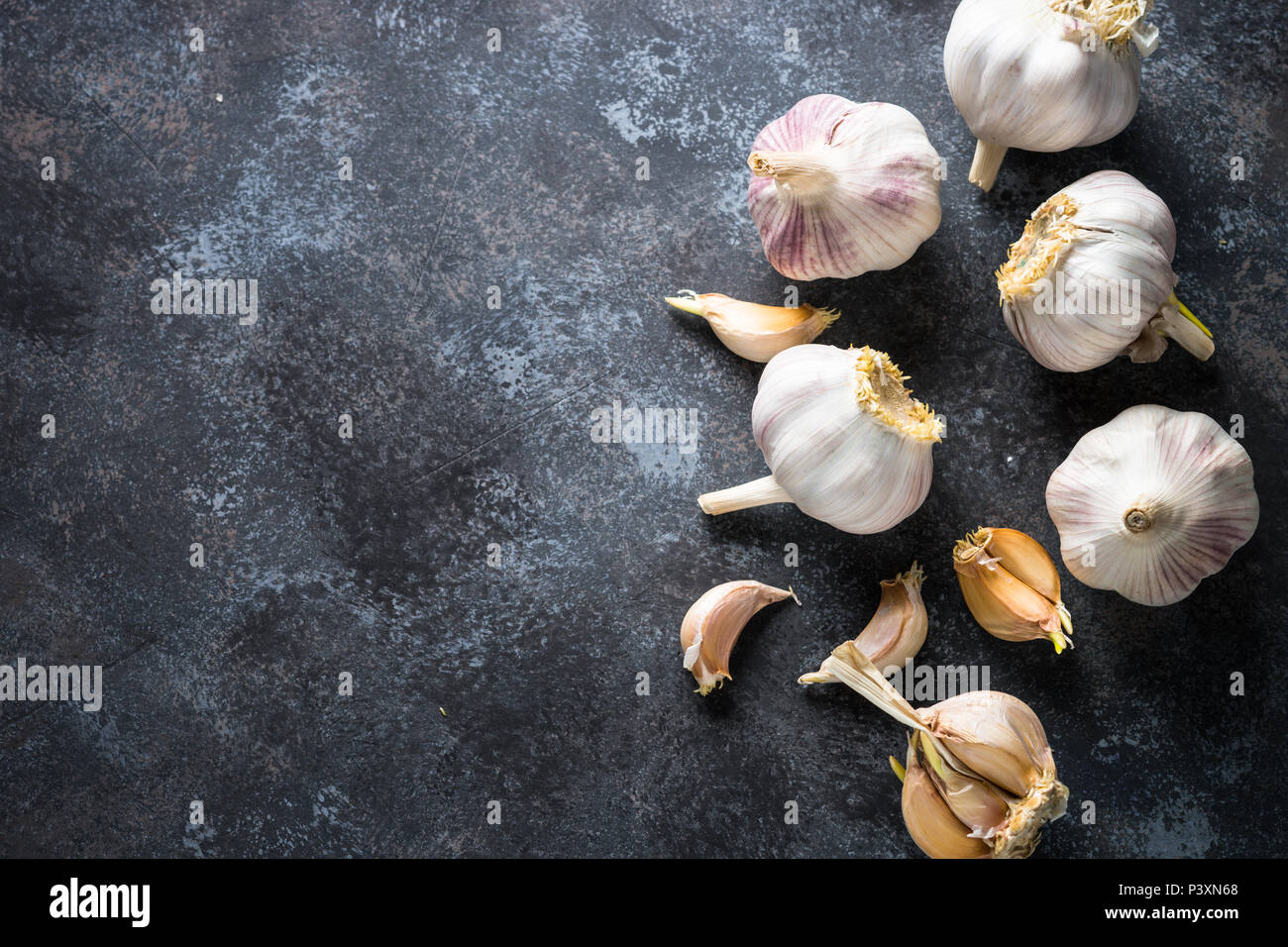 Garlic cloves on a dark stone background. Top view, Copy space Stock ...
