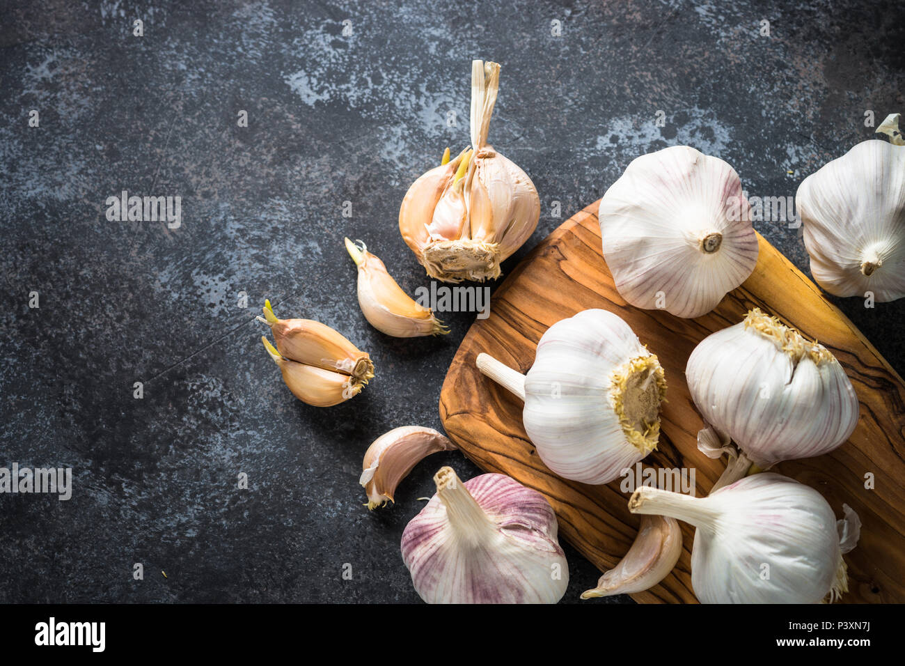 Garlic cloves on a dark stone background. Top view, Copy space Stock ...
