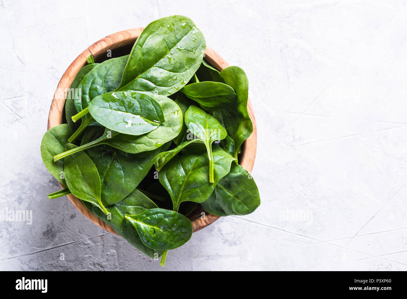 Baby spinach on gray stone table. Top view with copy space. Stock Photo