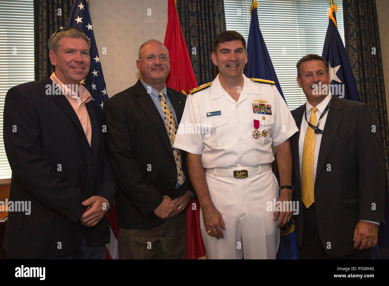 From left, Robert James, Richard Stryker, U.S. Navy Rear Adm. Brad Skillman, executive assisant to the Assistant Secretary of the Navy, Financial Management and Comptroller, and Thomas Conlon pose for a photo after a promotion ceremony at the Pentagon, Washington, D.C., July 22, 2016. Skillman was promoted from the rank of captain to rear admiral. (U.S. Marine Corps photo by Lance Cpl. Kayla V. Staten) Stock Photo