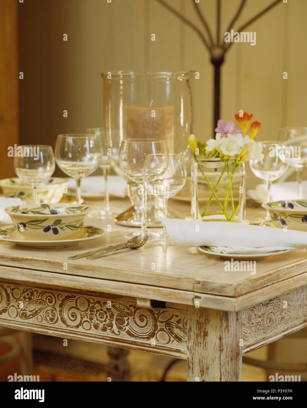 Close-up of glassware and crockery on lime-washed table set for lunch Stock Photo