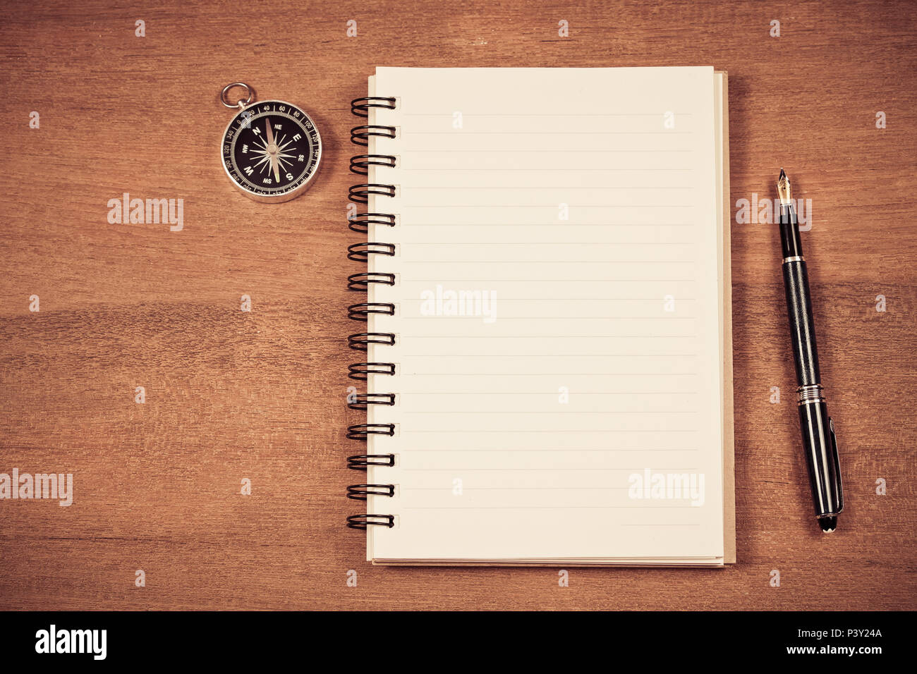 vintage compass on book note and fountain pen on wood table Stock Photo ...