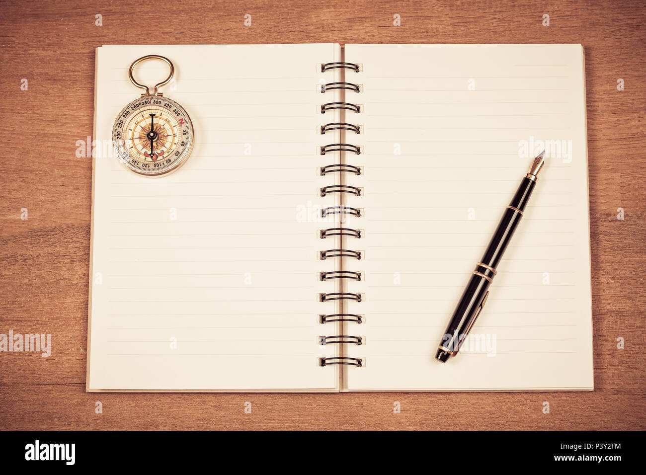 vintage compass on book note and fountain pen on wood table Stock Photo ...