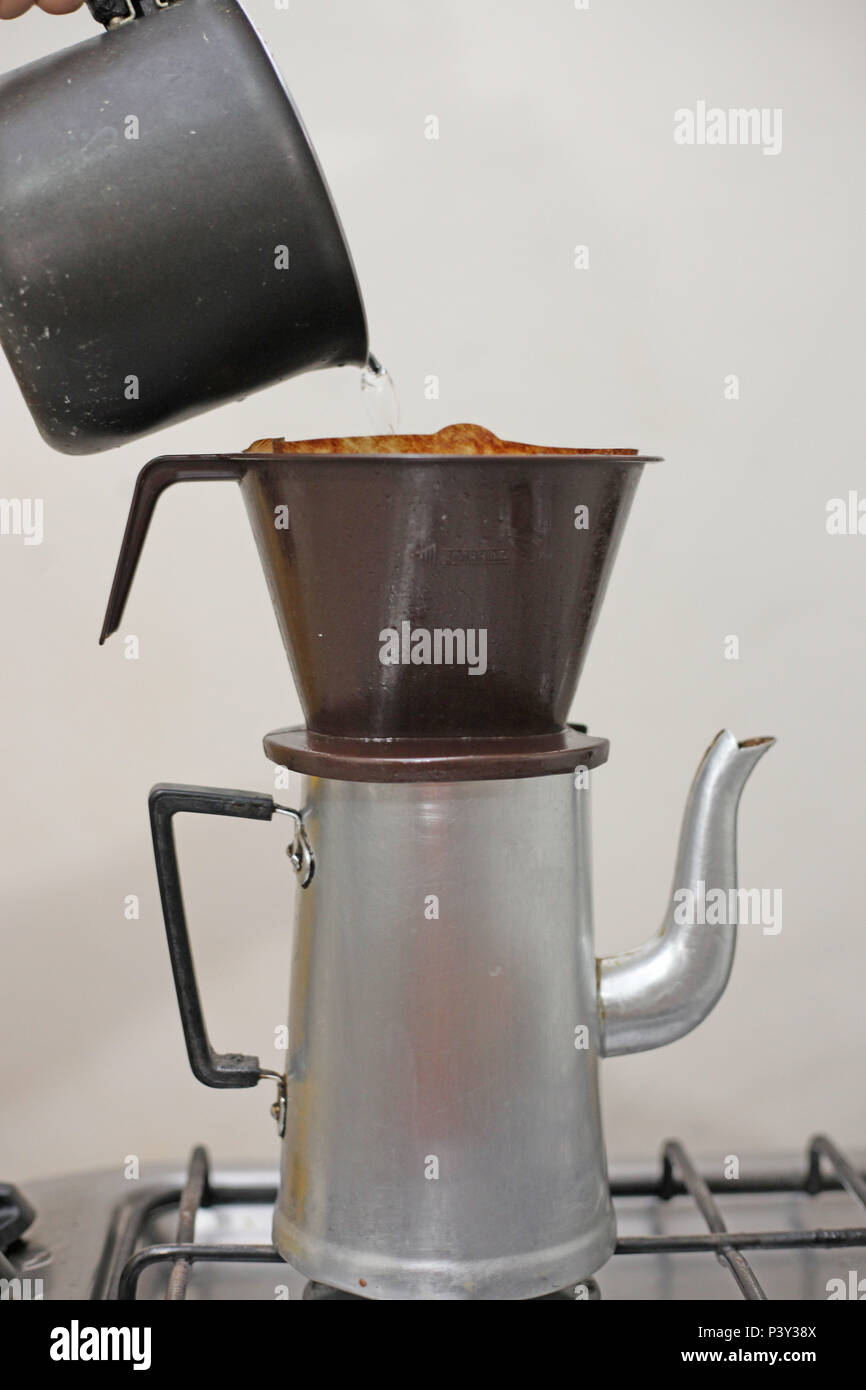 Coador de café de papel, com café em pó sendo molhado com água quente,  suporte de plástico e bule de alumínio Stock Photo - Alamy