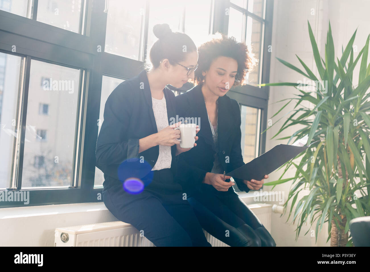 Two young colleagues reviewing business reports during break Stock Photo