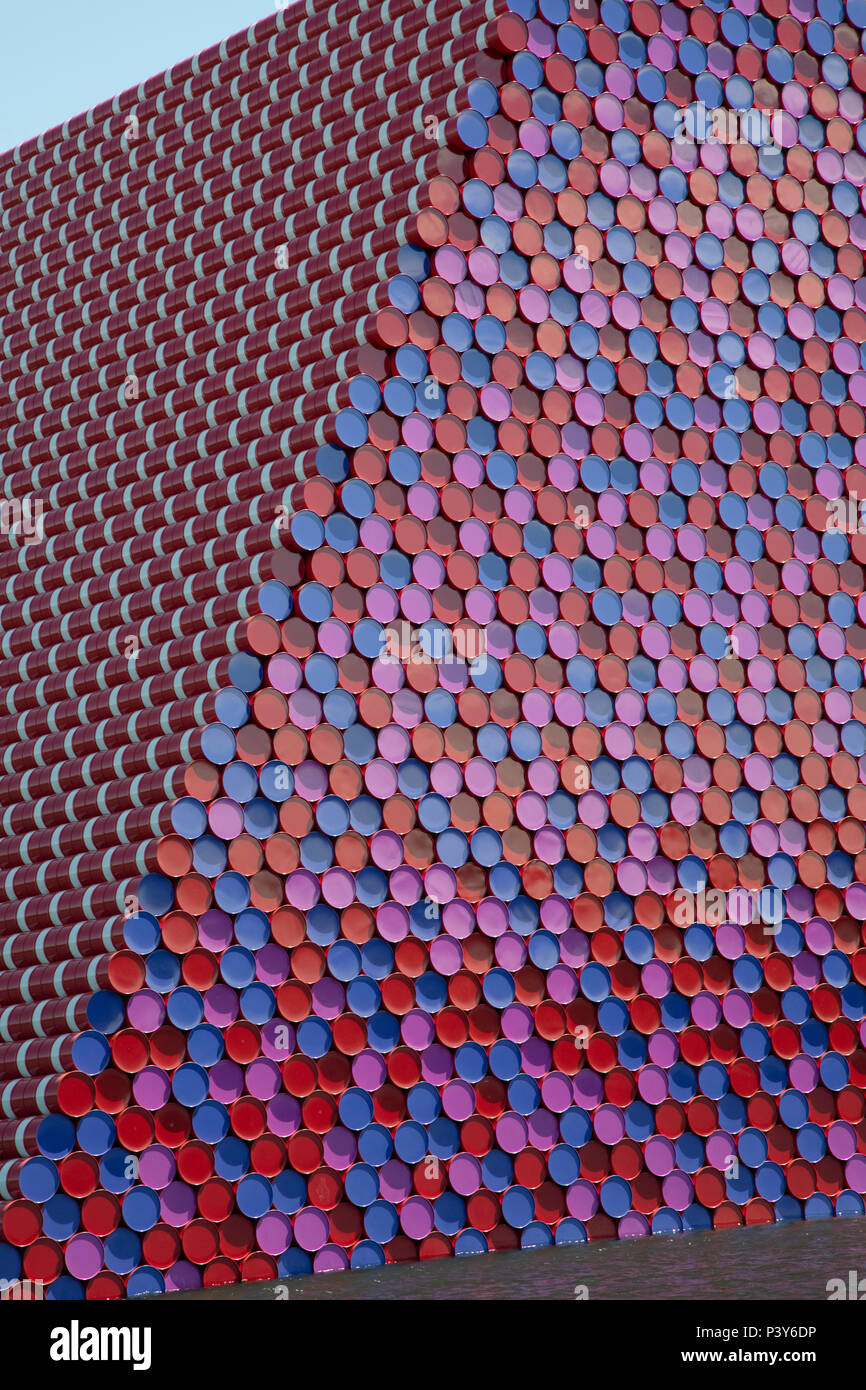 Art installation The Mastaba, by artist Christo, installed on the Serpentine lake in Hyde Park on June 18th 2018 in London, United Kingdom. The sculpture consists of 7,506 stacked barrels, painted in shades of red, white, blue and mauve. The completed piece forms part of an exhibition by Christo and his late wife, Jeanne-Claudes work, entitled Christo and Jeanne-Claude: Barrels and The Mastaba 19582018 to be held at The Serpentine Gallery. Stock Photo