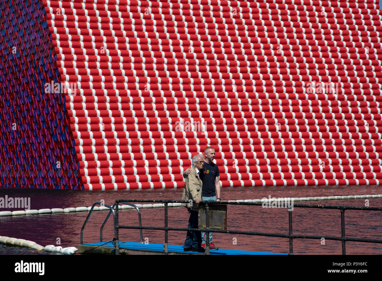 Artist Christo walks out onto a pontoon to view his art installation The Mastaba, by artist Christo, installed on the Serpentine lake in Hyde Park on June 18th 2018 in London, United Kingdom. The sculpture consists of 7,506 stacked barrels, painted in shades of red, white, blue and mauve. The completed piece forms part of an exhibition by Christo and his late wife, Jeanne-Claudes work, entitled Christo and Jeanne-Claude: Barrels and The Mastaba 19582018 to be held at The Serpentine Gallery. Stock Photo