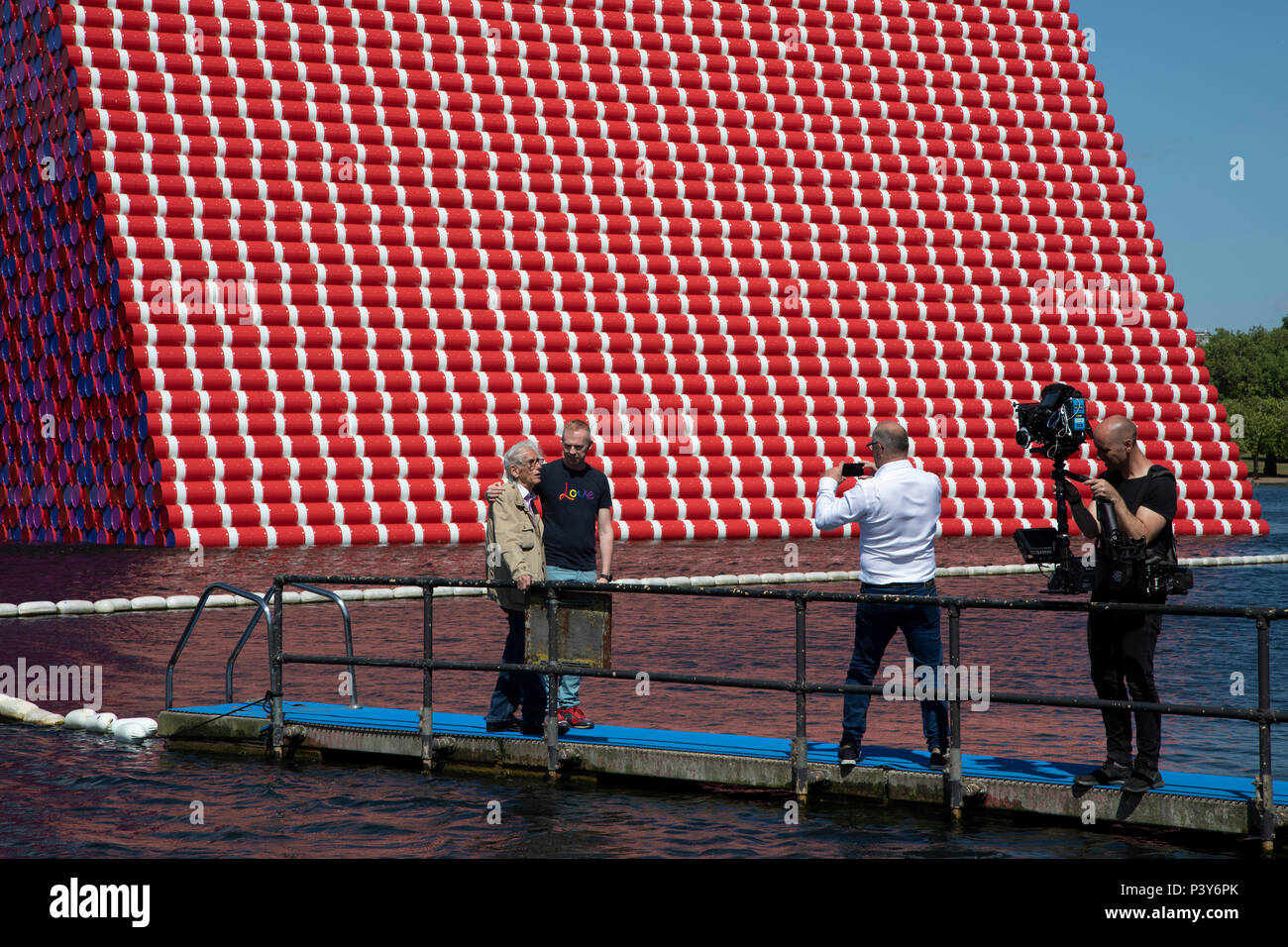 Artist Christo walks out onto a pontoon to view his art installation The Mastaba, by artist Christo, installed on the Serpentine lake in Hyde Park on June 18th 2018 in London, United Kingdom. The sculpture consists of 7,506 stacked barrels, painted in shades of red, white, blue and mauve. The completed piece forms part of an exhibition by Christo and his late wife, Jeanne-Claudes work, entitled Christo and Jeanne-Claude: Barrels and The Mastaba 19582018 to be held at The Serpentine Gallery. Stock Photo