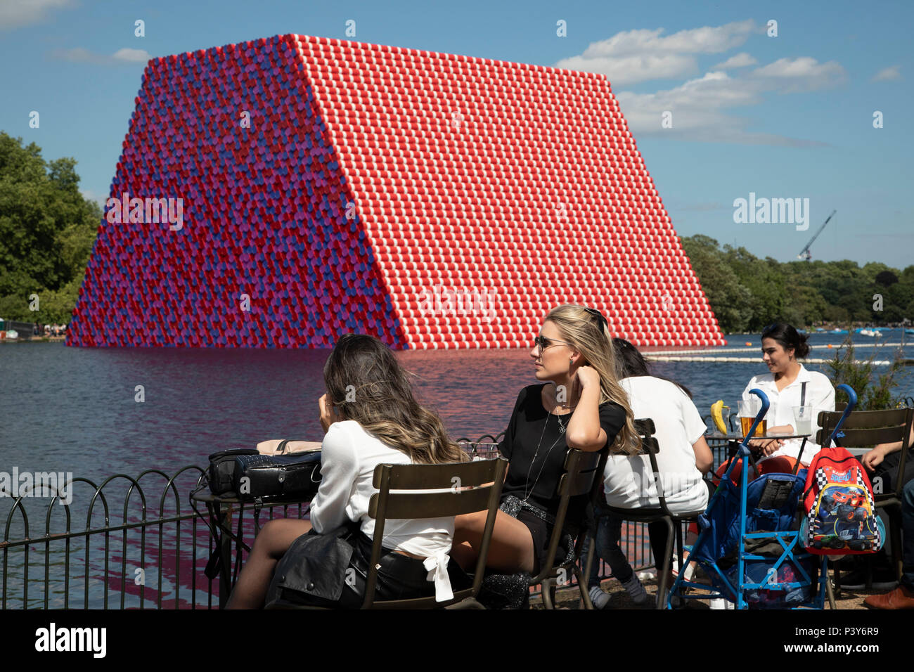 Art installation The Mastaba, by artist Christo, installed on the Serpentine lake in Hyde Park on June 18th 2018 in London, United Kingdom. The sculpture consists of 7,506 stacked barrels, painted in shades of red, white, blue and mauve. The completed piece forms part of an exhibition by Christo and his late wife, Jeanne-Claudes work, entitled Christo and Jeanne-Claude: Barrels and The Mastaba 19582018 to be held at The Serpentine Gallery. Stock Photo