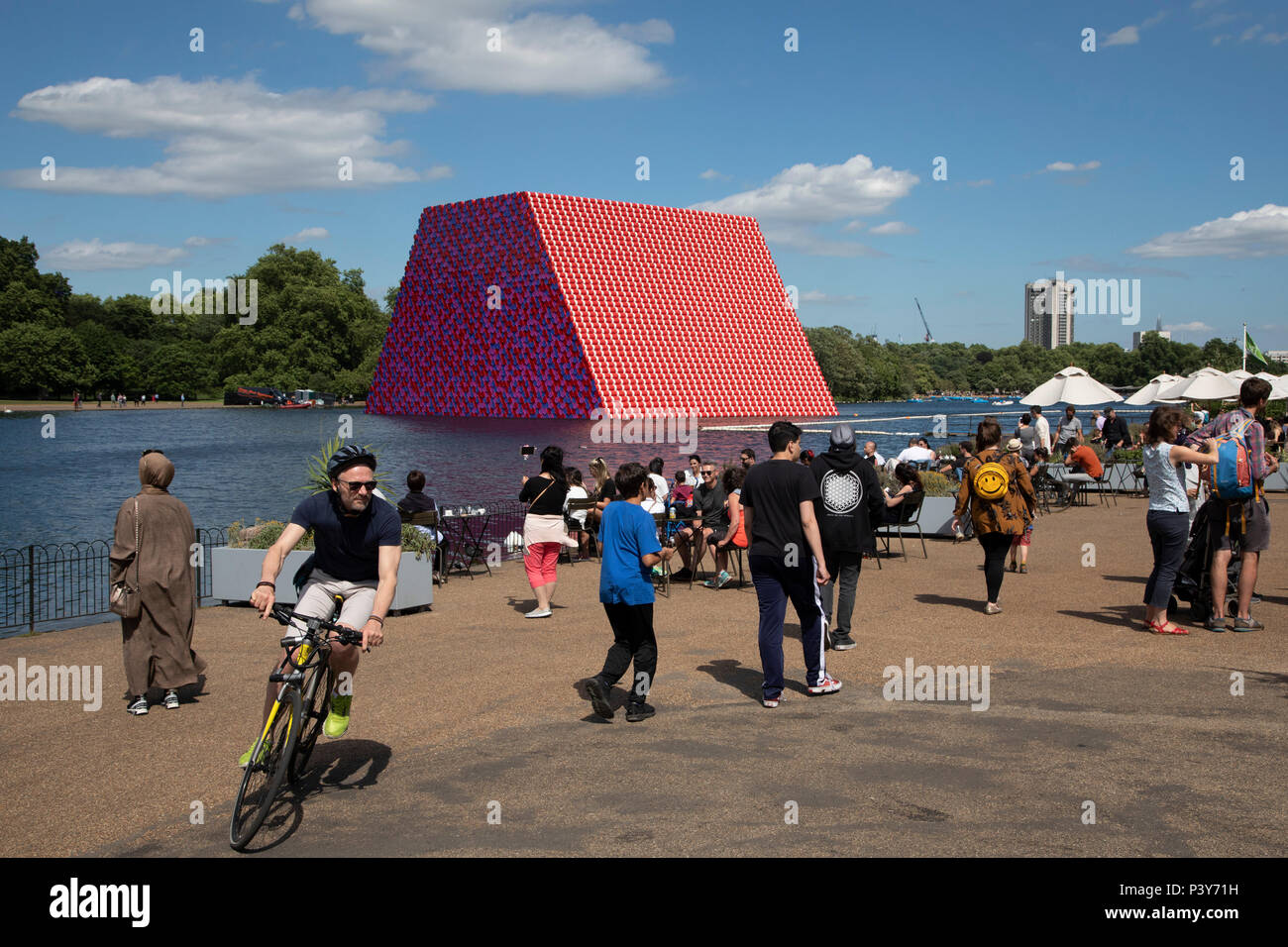 Art installation The Mastaba, by artist Christo, installed on the Serpentine lake in Hyde Park on June 18th 2018 in London, United Kingdom. The sculpture consists of 7,506 stacked barrels, painted in shades of red, white, blue and mauve. The completed piece forms part of an exhibition by Christo and his late wife, Jeanne-Claudes work, entitled Christo and Jeanne-Claude: Barrels and The Mastaba 19582018 to be held at The Serpentine Gallery. Stock Photo