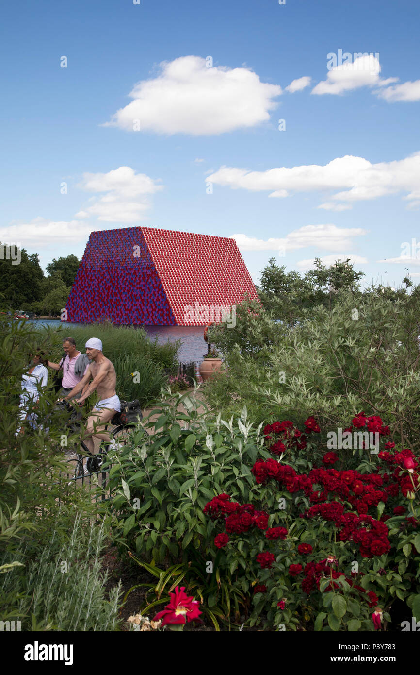 Art installation The Mastaba, by artist Christo, installed on the Serpentine lake in Hyde Park on June 18th 2018 in London, United Kingdom. The sculpture consists of 7,506 stacked barrels, painted in shades of red, white, blue and mauve. The completed piece forms part of an exhibition by Christo and his late wife, Jeanne-Claudes work, entitled Christo and Jeanne-Claude: Barrels and The Mastaba 19582018 to be held at The Serpentine Gallery. Stock Photo