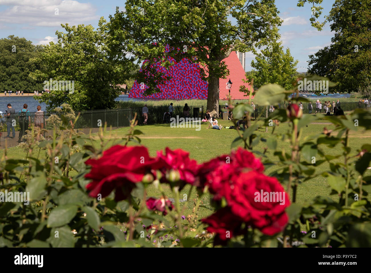 Art installation The Mastaba, by artist Christo, installed on the Serpentine lake in Hyde Park on June 18th 2018 in London, United Kingdom. The sculpture consists of 7,506 stacked barrels, painted in shades of red, white, blue and mauve. The completed piece forms part of an exhibition by Christo and his late wife, Jeanne-Claudes work, entitled Christo and Jeanne-Claude: Barrels and The Mastaba 19582018 to be held at The Serpentine Gallery. Stock Photo
