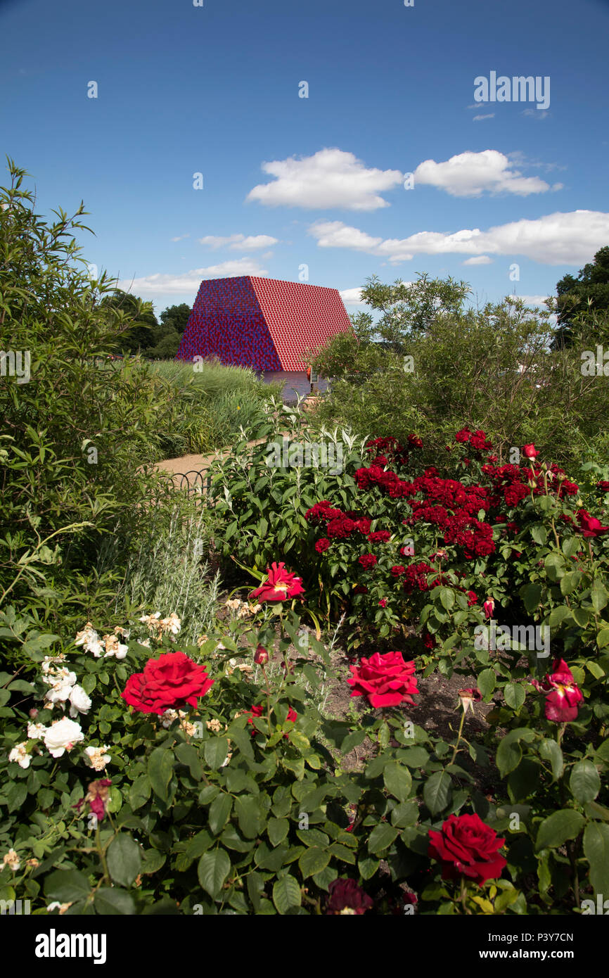 Art installation The Mastaba, by artist Christo, installed on the Serpentine lake in Hyde Park on June 18th 2018 in London, United Kingdom. The sculpture consists of 7,506 stacked barrels, painted in shades of red, white, blue and mauve. The completed piece forms part of an exhibition by Christo and his late wife, Jeanne-Claudes work, entitled Christo and Jeanne-Claude: Barrels and The Mastaba 19582018 to be held at The Serpentine Gallery. Stock Photo