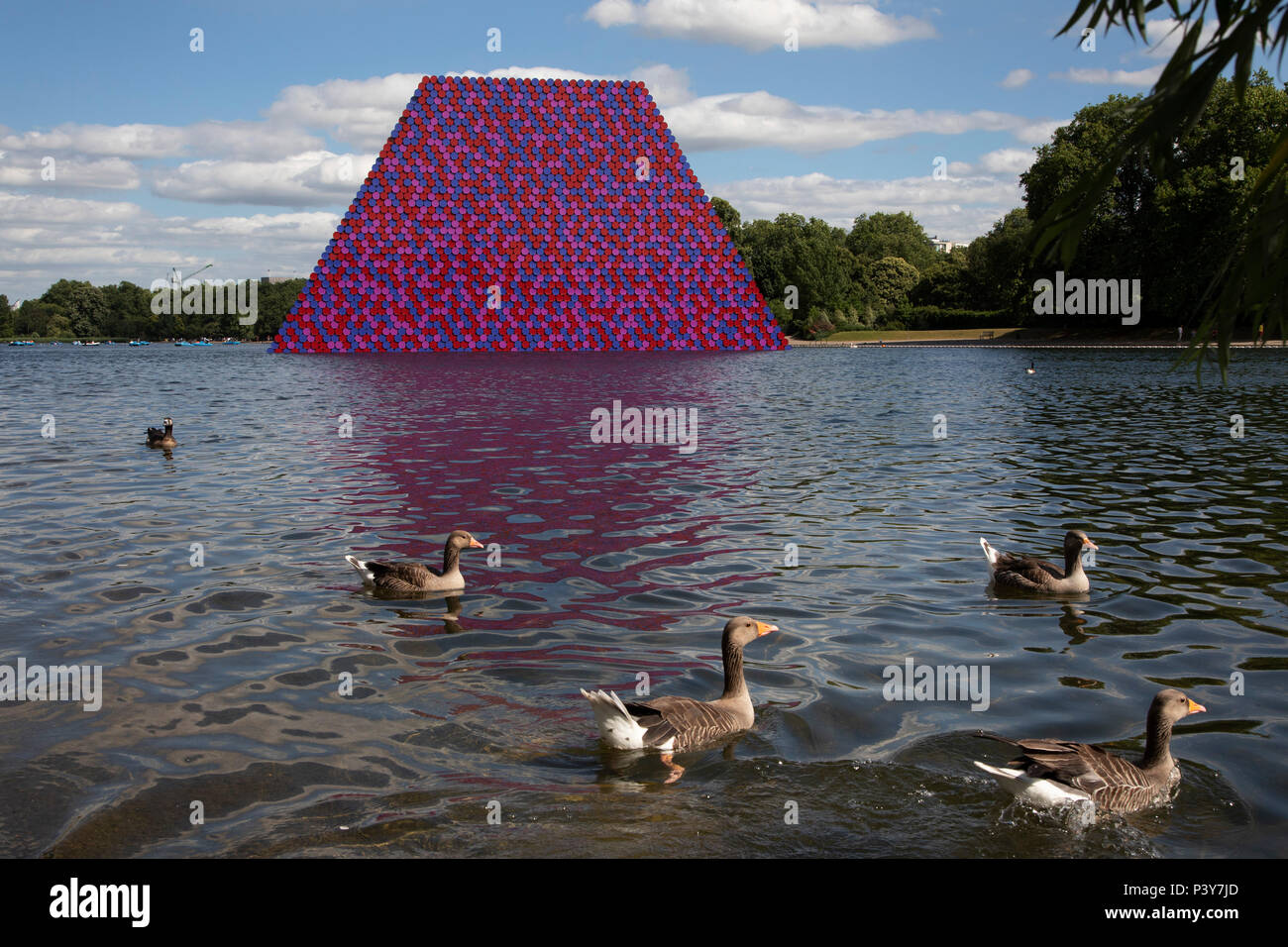 Art installation The Mastaba, by artist Christo, installed on the Serpentine lake in Hyde Park on June 18th 2018 in London, United Kingdom. The sculpture consists of 7,506 stacked barrels, painted in shades of red, white, blue and mauve. The completed piece forms part of an exhibition by Christo and his late wife, Jeanne-Claudes work, entitled Christo and Jeanne-Claude: Barrels and The Mastaba 19582018 to be held at The Serpentine Gallery. Stock Photo