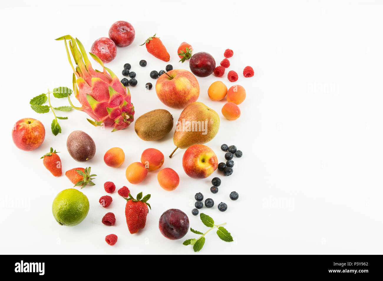 Obst, Früchte-Mix, Erdbeeren, Himbeeren, Blaubeeren, Äpfel, Birnen, Limette, Kiwi, Pflaumen, Aprikosen, Drachenfrucht und Minze Stock Photo
