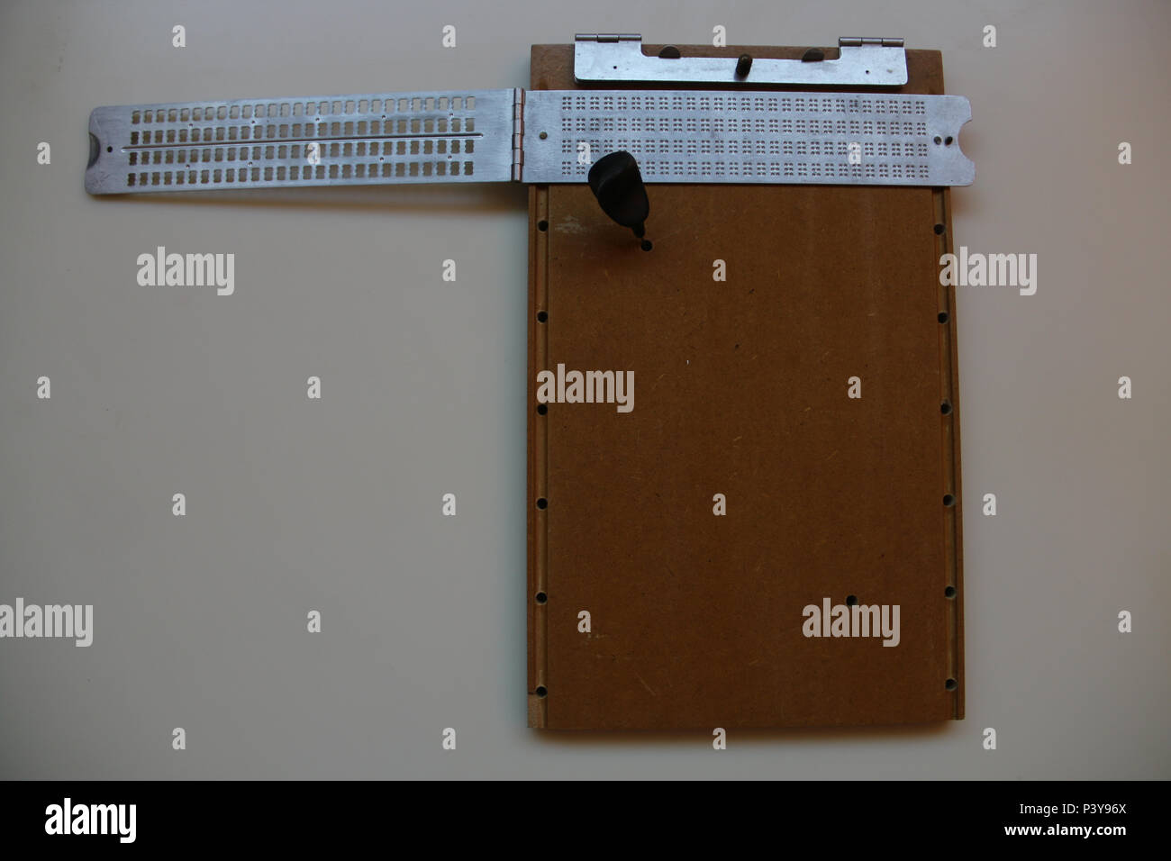 Reglete que serve para fazer os símbolos de letras e números para braille. Stock Photo